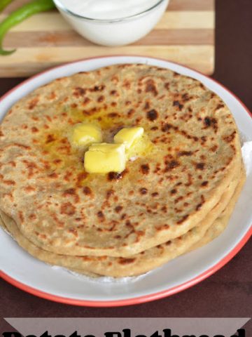 aloo paratha served in a plate with butter and curd.