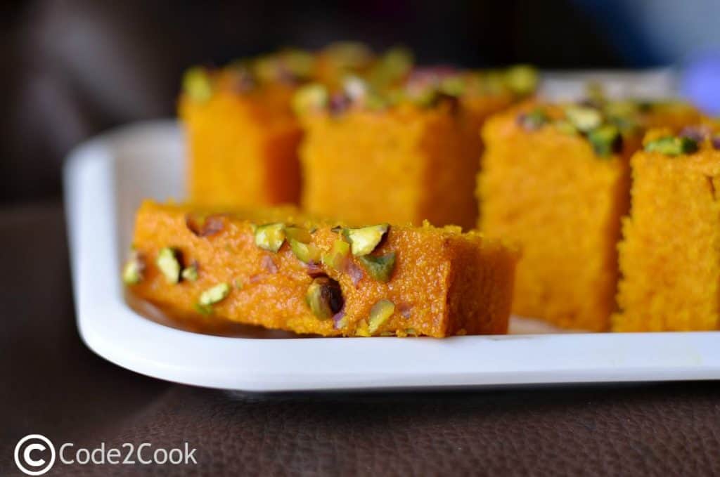 Eggless mango semolina cake is super easy to prepare.  This cake is moist, dense in texture and so aromatic with its delicious mango flavor. Mango pulp folded with semolina, cardamom, and few handful nuts gives you chewy experience with every bite.  A perfect cake to bake in mango season and you can never go wrong with it.