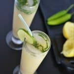 Sattu drink served in tall glass with lemon wedges.