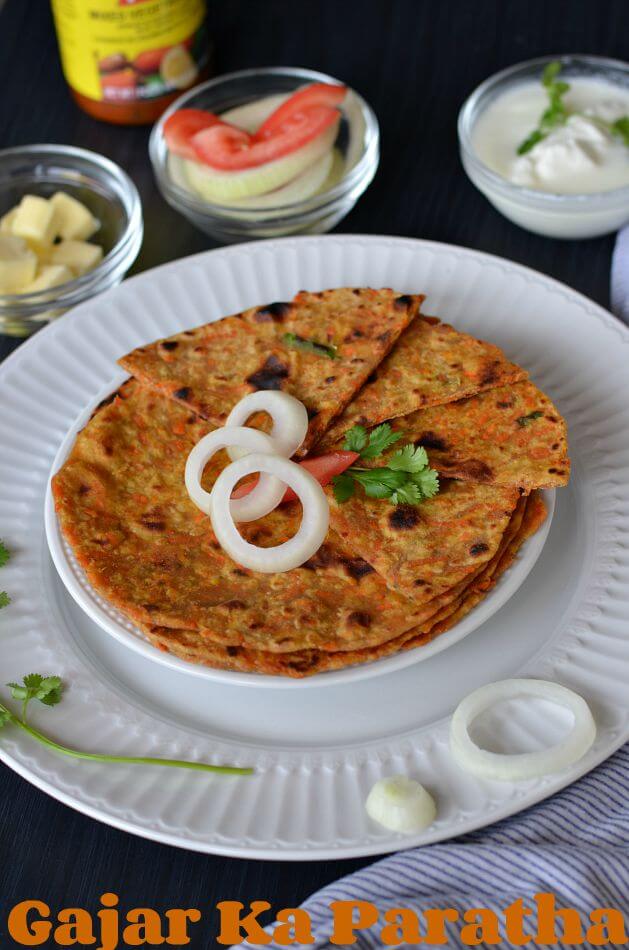 Gajar ka paratha or carrot paratha is a simple Indian flatbread which is healthy and delicious. Grated carrot mixed in whole wheat flour, flavored with cumin seed powder, chopped green chili, chopped green coriander, make a soft dough and roll out hot parathas. Makes a perfect breakfast or kids lunch box recipe.