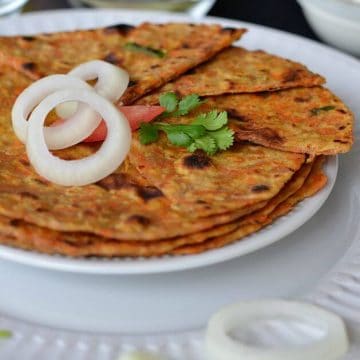 Gajar ka paratha or carrot paratha is a simple Indian flatbread which is healthy and delicious. Grated carrot mixed in whole wheat flour, flavored with cumin seed powder, chopped green chili, chopped green coriander, make a soft dough and roll out hot parathas. Makes a perfect breakfast or kids lunch box recipe.
