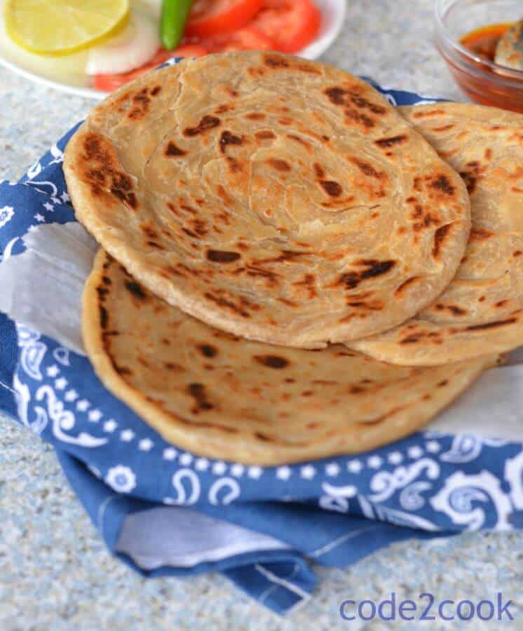 Kerala Parotta or Malabar parotta is a unique parotta dish from Malayali cuisine. It is a layered paratha or flaky paratha made with refined flour. Kerala parotta is a common street food in southern India. It is served with vegetable kurma or coconut stew.