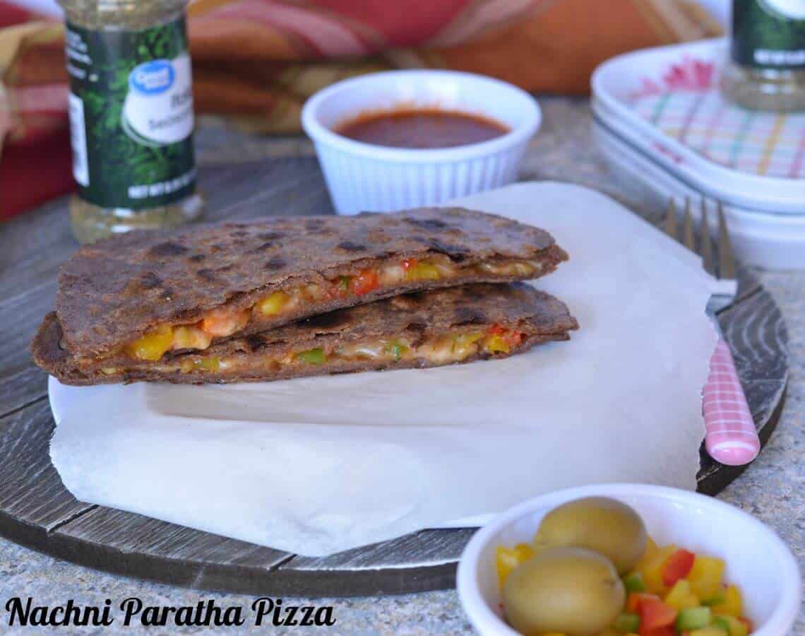 Pizza paratha is a stuffed flatbread which tastes like pizza and popular among kids. It is a fusion between paratha (Indian flatbread) and Italian Pizza. Basically, it is an Indian paratha (flatbread), which is stuffed with pizza sauce and vegetables filling with cheese. Cooked on the stove top like a  paratha.