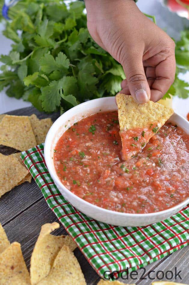 Tomato salsa is one of the most popular Mexican side dish served with tortilla chips. It is tomato based sauce and great with chips, tacos, burritos, and wraps.