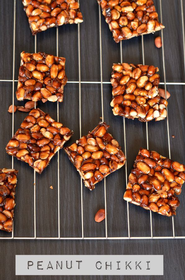 close up click for peanut chikki. Placed on rack and peanuts are scattered around.