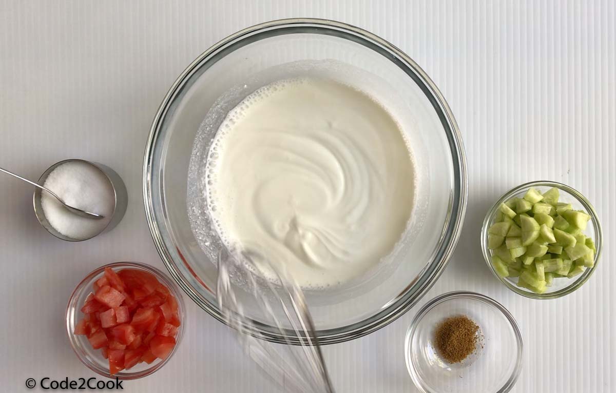 whisking greek yogurt with water. Other ingredients are kept around.