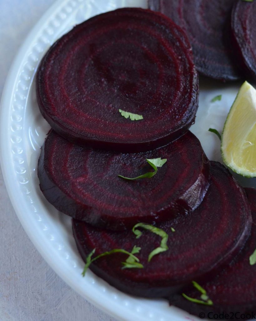 close up shot of steamed beets, served in white plate.