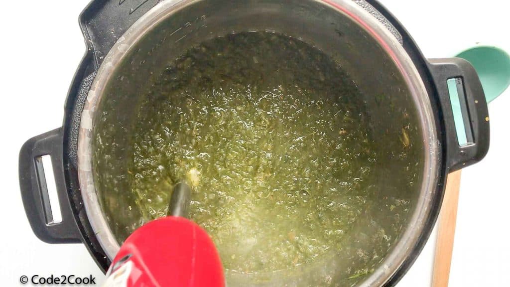 blending cooked saag using immersion blender
