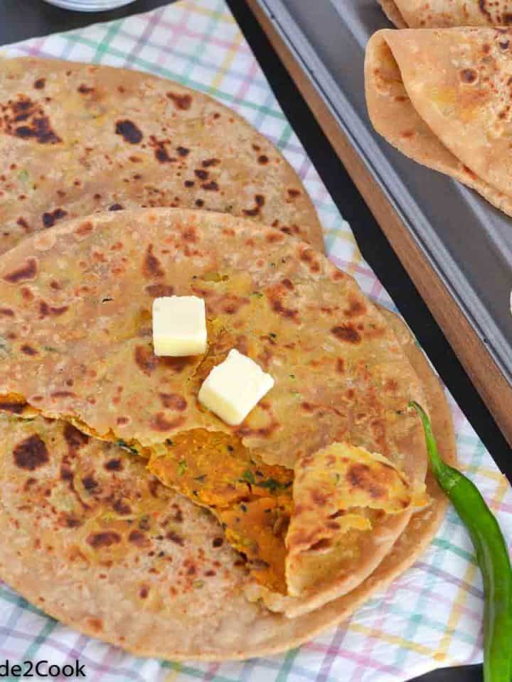 close up click of masala paratha with butter cubes