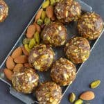 over head shot of dry fruits laddu with dates kept in a silver plate.