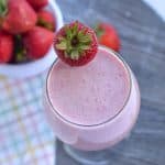 sugar free strawberry milkshake served in a glass with strawberry in it.