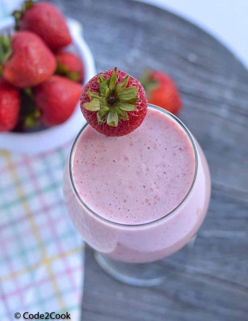 sugar free strawberry milkshake served in a glass with strawberry in it.