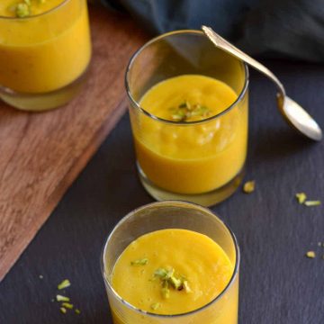 aamras is served in small glasses, garnished with chopped nuts