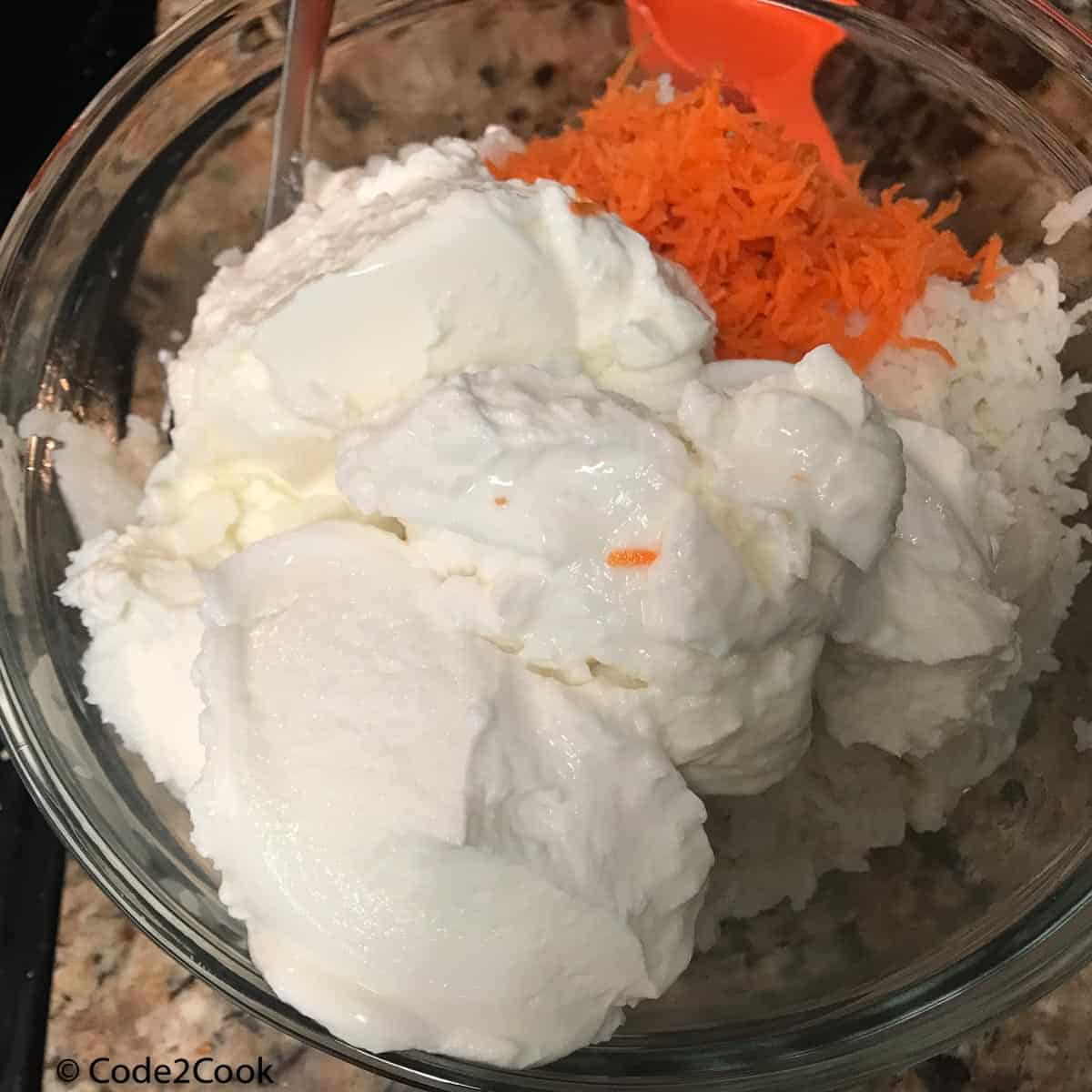 mixing yogurt, grated carrot, salt,water in cooked rice