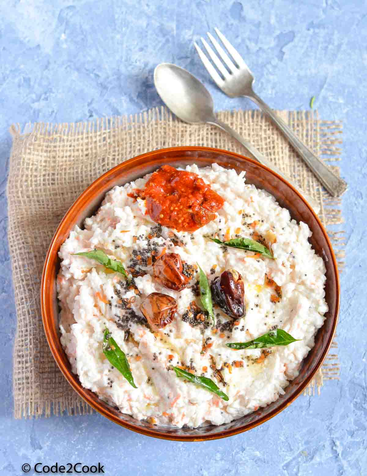 curd rice served in a bowl with pickle & tempering