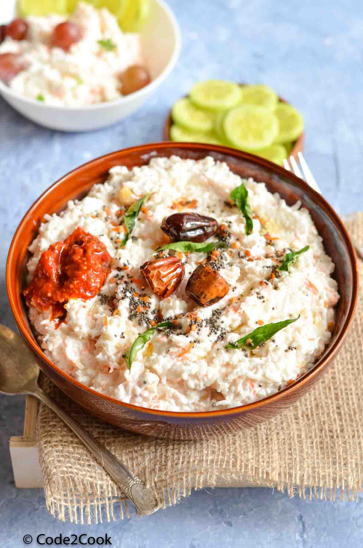 curd rice served with pickle and garnished with tempering