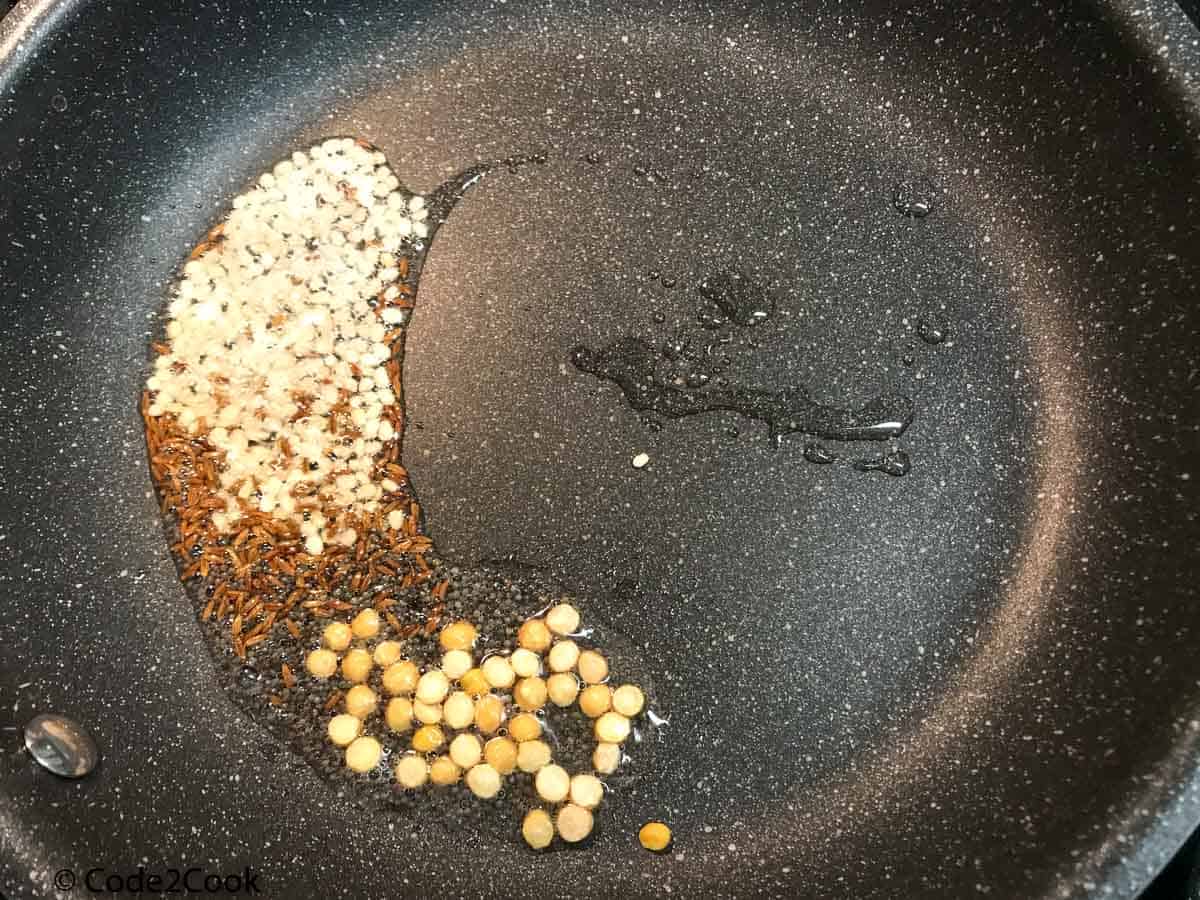 Adding lentils, cumin, mustard seeds in oil